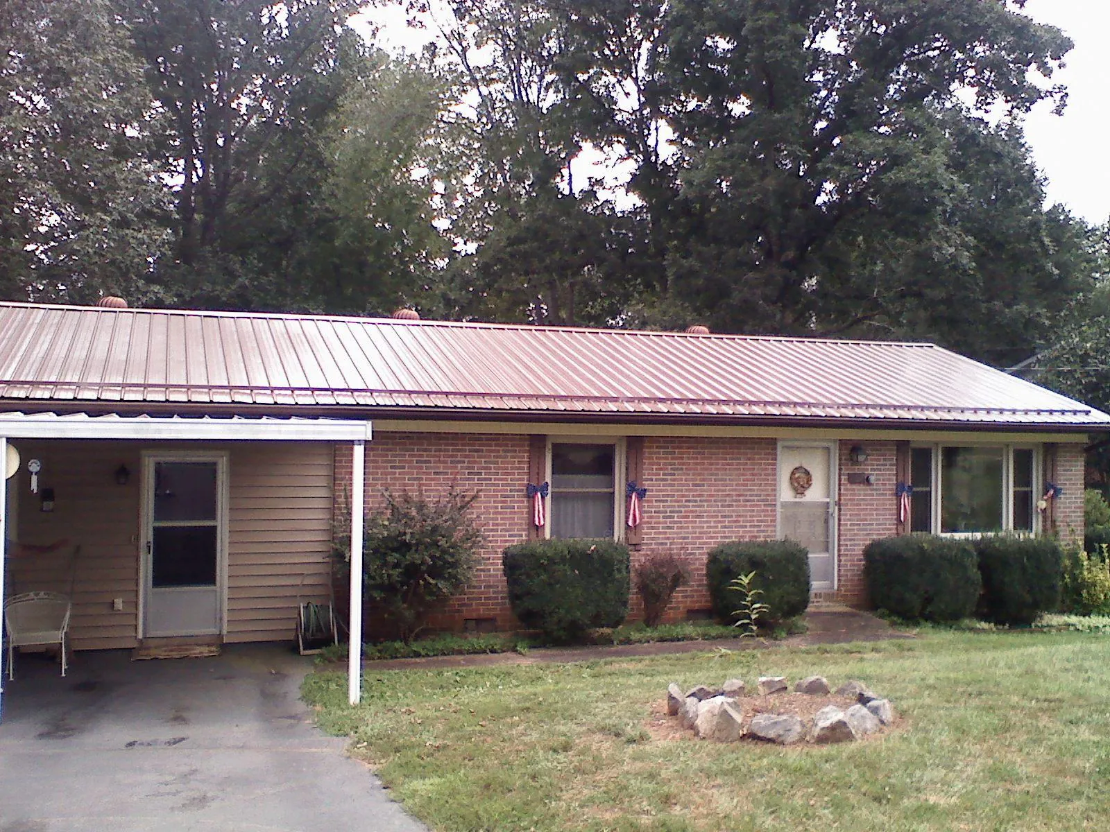Bronze metal roof and carport on a brick ranch home — Roof Repair work by our crew in Big Sandy